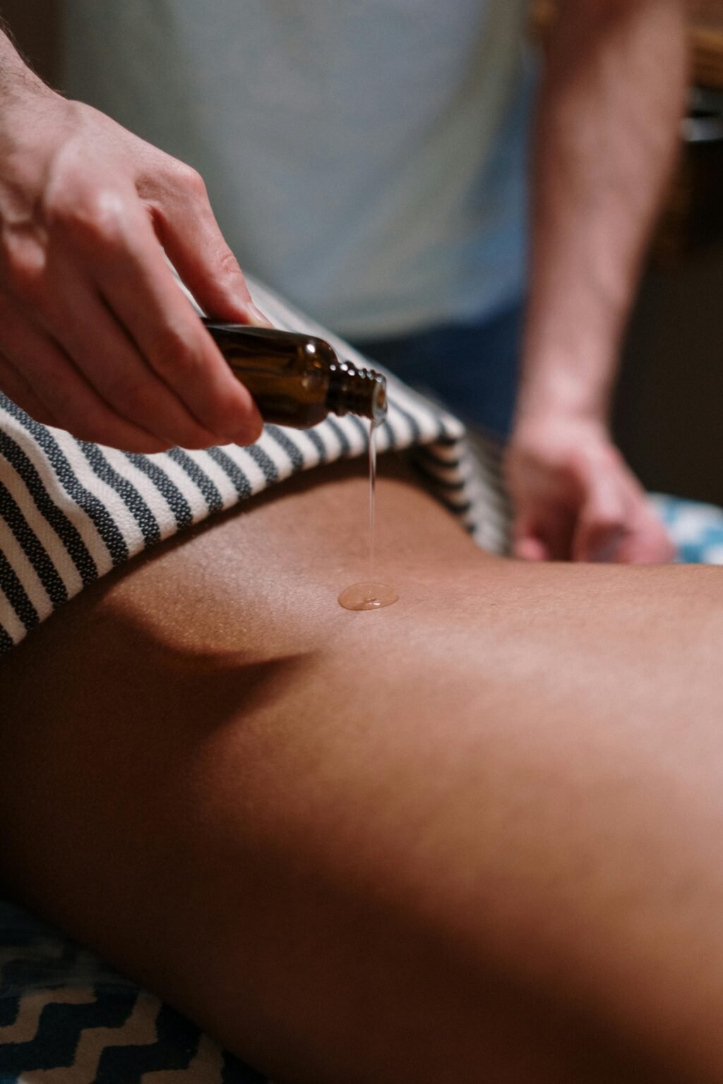 oil being poured on a back for a massage